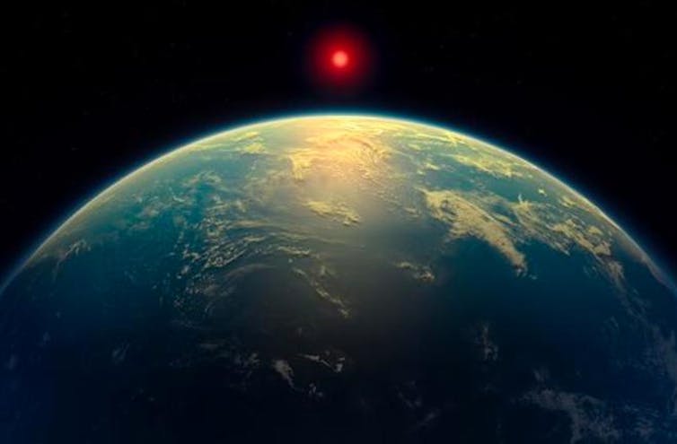 An illustration of what scientists imagine K2-18b to look like, which looks a little like Earth, with clouds and a translucent surface.